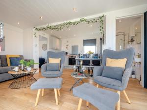 a living room with two blue chairs and a kitchen at Galloway Ewe - Uk46819 in Wigtown