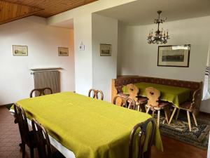 a dining room with a green table and chairs at CASA PINUCCIA MANSARDA in Predazzo +10 photos