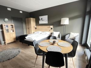 Trysil Alpine Lodge في تريسيل: غرفة نوم بسرير وطاولة وكراسي