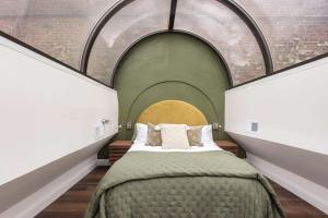 a bedroom with a large bed with an archway at Modern Mid Century Getaway. Luxury by Hollyhock in Louisville
