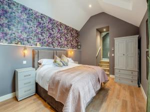 een slaapkamer met een groot bed met een bloemaccentmuur bij Ling At Holly House - Uk44468 in Newton