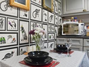 eine Küche mit einem Tisch und schwarzen und weißen Tapeten in der Unterkunft Hebble Row Cottage in Oakworth