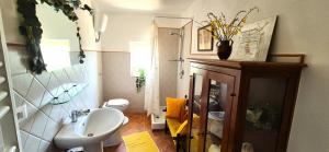 une salle de bain avec un lavabo blanc et des toilettes dans l'établissement La Casa dei Ricordi Centro Storico E Vista, à Pitigliano 25 autres photos