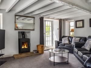 un soggiorno con divano e camino di Box Tree Farmhouse - Uk47034 a Kirkby Lonsdale