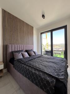 ein Schlafzimmer mit einem großen Bett und einem großen Fenster in der Unterkunft Luxury Penthouse Sarajevo in Sarajevo