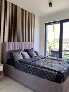 un grand lit dans une chambre avec une grande fenêtre dans l'établissement Luxury Penthouse Sarajevo, à Sarajevo