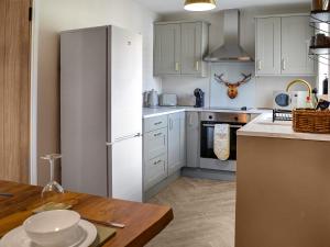 uma cozinha com um frigorífico branco e uma mesa em Canda em Holywood