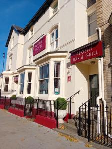 a white building with a sign for a bar and grill at Regent Hotel Doncaster in Doncaster