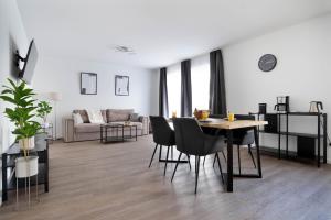 a living room with a table and chairs and a couch at Schöne Apartments in Lengerich I home2share in Lengerich