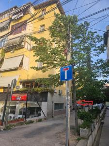 地拉那的住宿－Xhemi APARTAMENT，建筑前的蓝色街道标志