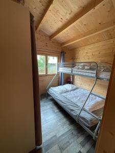 pokój z 2 łóżkami piętrowymi w drewnianym domku w obiekcie Camping Le Convivial w mieście Foncène +37 zdjęć