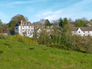 a large building on top of a green field at Treetops in Woodchester