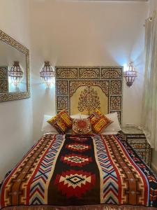 una camera da letto con un grande letto con un copriletto colorato di Zoco Riad a Tangeri