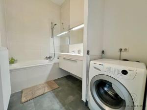 a white bathroom with a washing machine in it at Le Botanique des Augustins -100m2 en plein centre in Liège