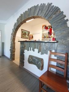 a woman standing behind a counter in a brick wall at Casa Talika in Fátima