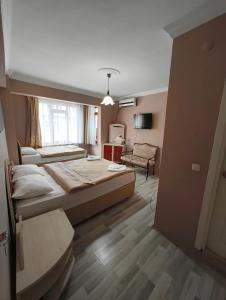 a bedroom with a large bed and a living room at Tac Pansiyon in Edirne