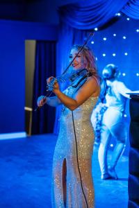 a woman is playing a violin on a stage at Marian Resort And Spa in Prestatyn