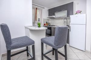 kuchnia z 2 krzesłami i białą lodówką w obiekcie Apartments Dragons Eye Rogoznica (3338) w Rogoznicy
