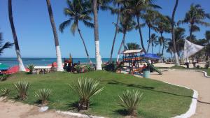 a playground on the beach with palm trees and the ocean at Apartamento na Praia do Francês AL in Praia do Frances