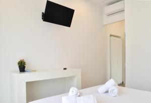 Habitación con 2 camas y TV en la pared. en Il Giramondo, en Agropoli