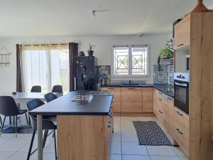 a kitchen with wooden cabinets and a black refrigerator at TURQUOISE in Linxe