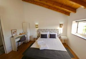 een slaapkamer met een groot bed en een raam bij Casa do Chafariz - Rooms in Cercal