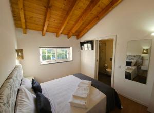a bedroom with a large bed and a bathroom at Casa do Chafariz - Rooms in Cercal