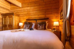 een slaapkamer met een bed in een houten kamer bij Hôtel Au Chamois d'Or by Les Etincelles in L'Alpe-d'Huez