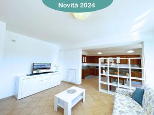 a living room with a couch and a tv at Appartamenti La Risacca - ArgonautiVacanze in Capoliveri