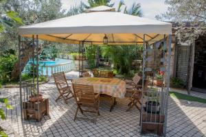 a table and chairs under an umbrella on a patio at Cottage Milvia in Tortoreto Lido