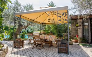 a patio with a table and chairs under a yellow umbrella at Cottage Milvia in Tortoreto Lido