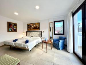 a bedroom with a bed and a table and a chair at Room with breakfast included, balcony, WiFi, pool in Yaiza in Yaiza +30 photos