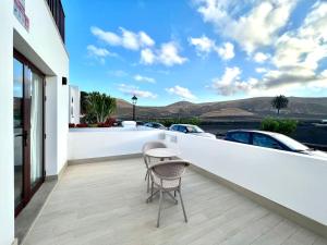 a table and chairs on a balcony with a view of cars at Room with breakfast included, balcony, WiFi, pool in Yaiza in Yaiza
