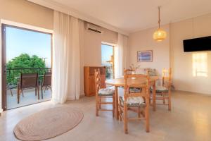 a dining room with a table and chairs and a balcony at PROPERSTAY 101 - Casa Leonardo Chalkidiki in Polychrono