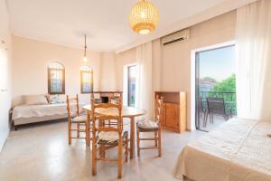 a room with a table and chairs and a bedroom at PROPERSTAY 101 - Casa Leonardo Chalkidiki in Polychrono