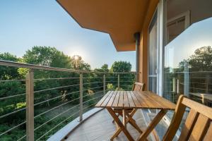 a wooden table on a balcony with a view at Moana Sunset Apartment in Ahtopol