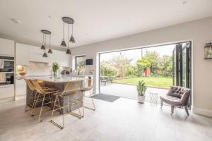 a kitchen and living room with a table and chairs at Windsor Charm Spacious 3-Bed, Parking & Garden - By Tempstay in Windsor
