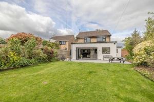 a house with a lawn in front of a yard at Windsor Charm Spacious 3-Bed, Parking & Garden - By Tempstay in Windsor