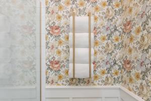 a towel rack in a bathroom with floral wallpaper at Fancy Heart of Kentucky Suite in Louisville