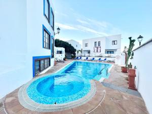 a swimming pool in a yard next to a building at Room with breakfast included, balcony, WiFi, pool in Yaiza in Yaiza