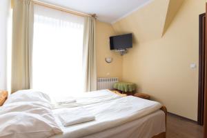 - un lit blanc dans une chambre avec fenêtre dans l'établissement Willa Sport, à Zakopane