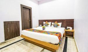 um quarto com uma cama grande num quarto em FabHotel Golden Pettals em Gurgaon
