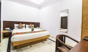 um quarto com uma cama king-size e um espelho em FabHotel Golden Pettals em Gurgaon