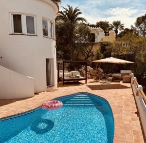 a swimming pool in front of a house at Ibiza Dream Villa Denia, Seaview, Pool, BBQ, Airco, Wifi in Denia