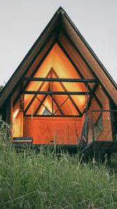 une petite cabine avec une grande fenêtre dans un champ d'herbe dans l'établissement Ecolodge Cuentos de Agua, à Villamaría