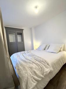 a bedroom with a bed with white sheets and pillows at Charmant 2 Pièces coeur de Bastia in Bastia