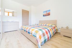 a white bedroom with a bed with a colorful blanket at 267 - Casa Paradise B1, nel verde di Casarza a 15 minuti d'auto dal Mare - PARCHEGGIO PRIVATO INCLUSO in San Lazzaro