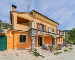 an orange house with a balcony and a patio at 267 - Casa Paradise B1, nel verde di Casarza a 15 minuti d'auto dal Mare - PARCHEGGIO PRIVATO INCLUSO in San Lazzaro