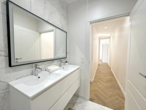 uma casa de banho branca com um lavatório e um espelho em 3 pièces rénové Limitrophe Monaco em Beausoleil