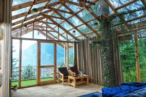Habitación con cama, silla y mesa. en Stargazing Treehouse Himachal, en Sainj